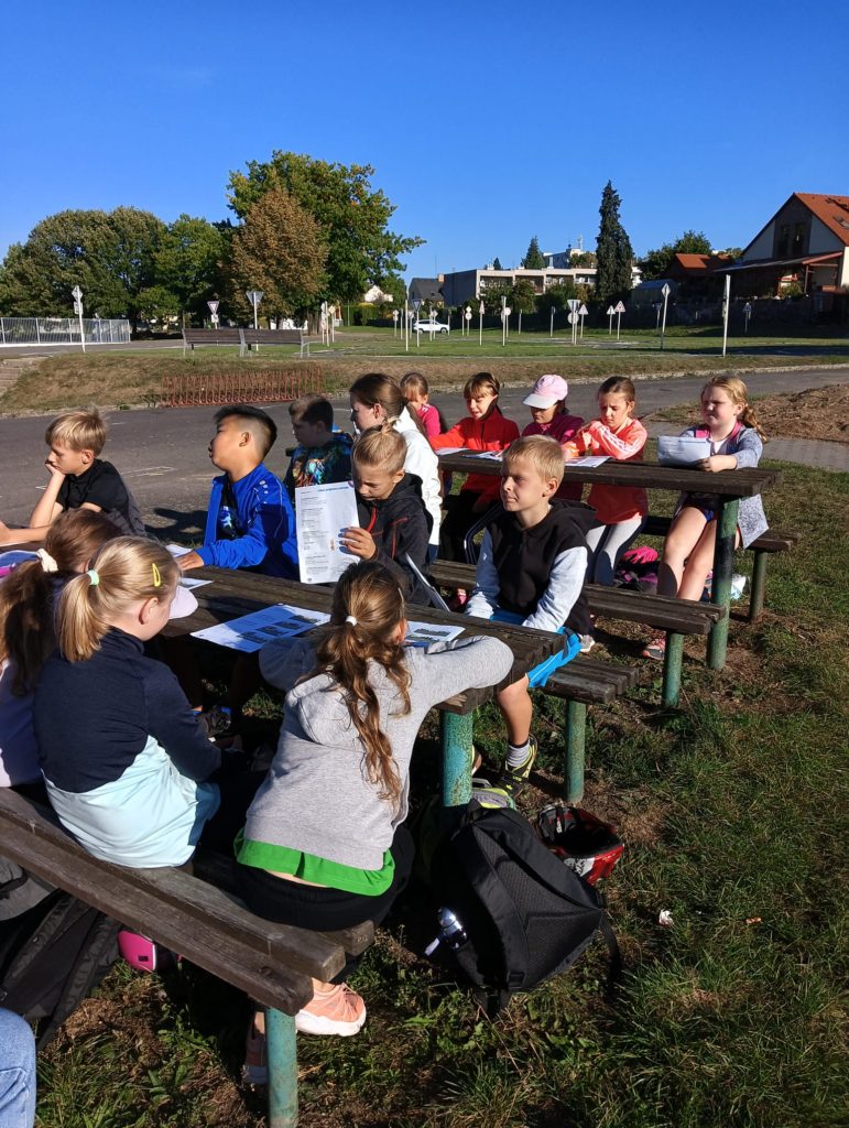 žáci na lavičkách před dopravním hřištěm
