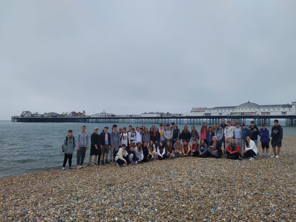 žáci na oblázkové pláži v přístavním městě Brighton