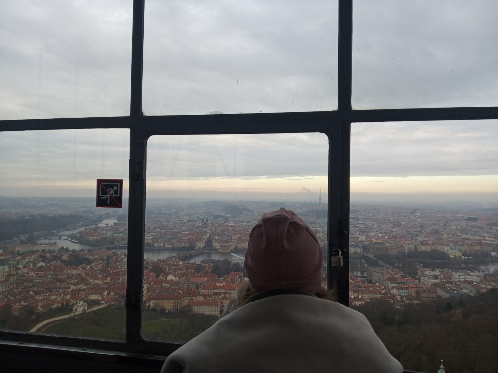 žákyně dívající se na vrcholu Petřínské rozhledny na střed Prahy