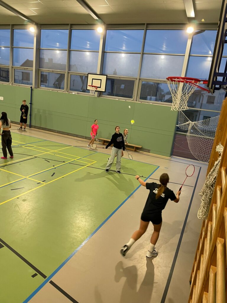 žáci hrající badminton po celé tělocvičně