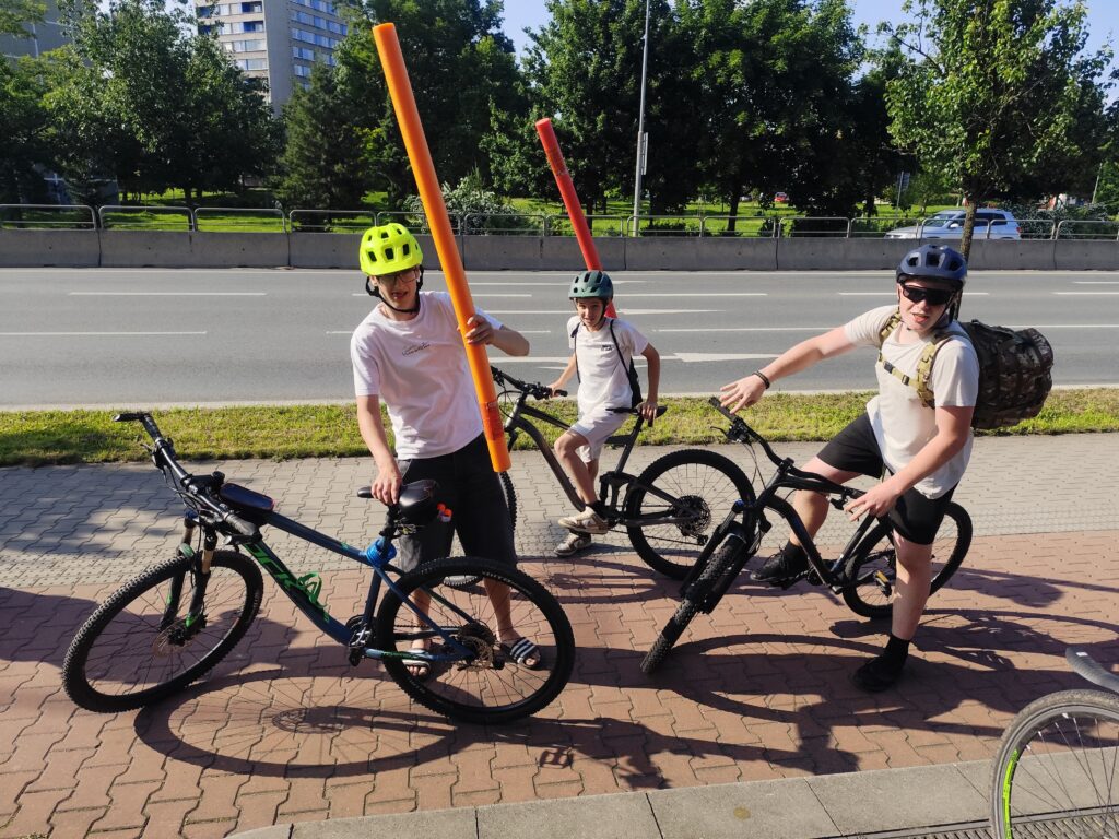 3 chlapci na kolech před Lidlem